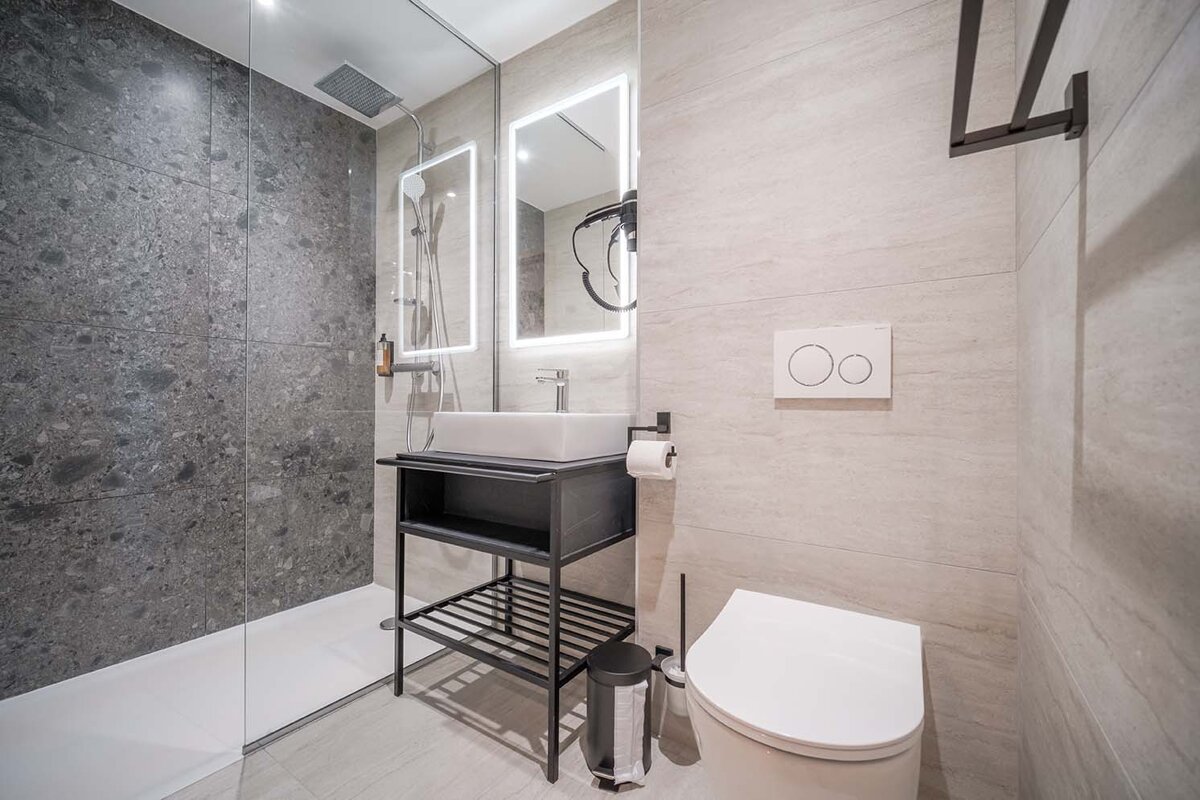 A bathroom with a toilet a sink and a mirror