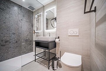 A bathroom with a toilet a sink and a mirror