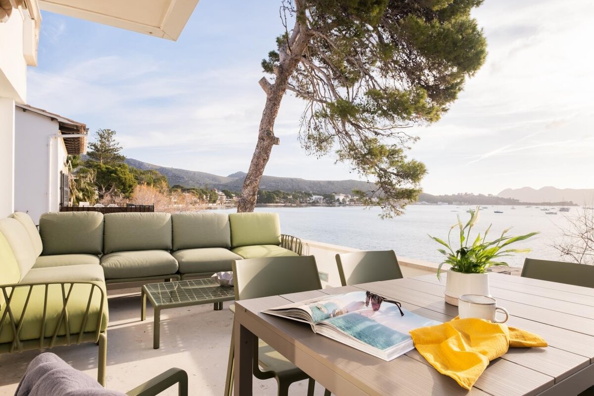 A table with a magazine on it and a view of the ocean