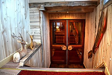 A wooden staircase leading up to a glass door