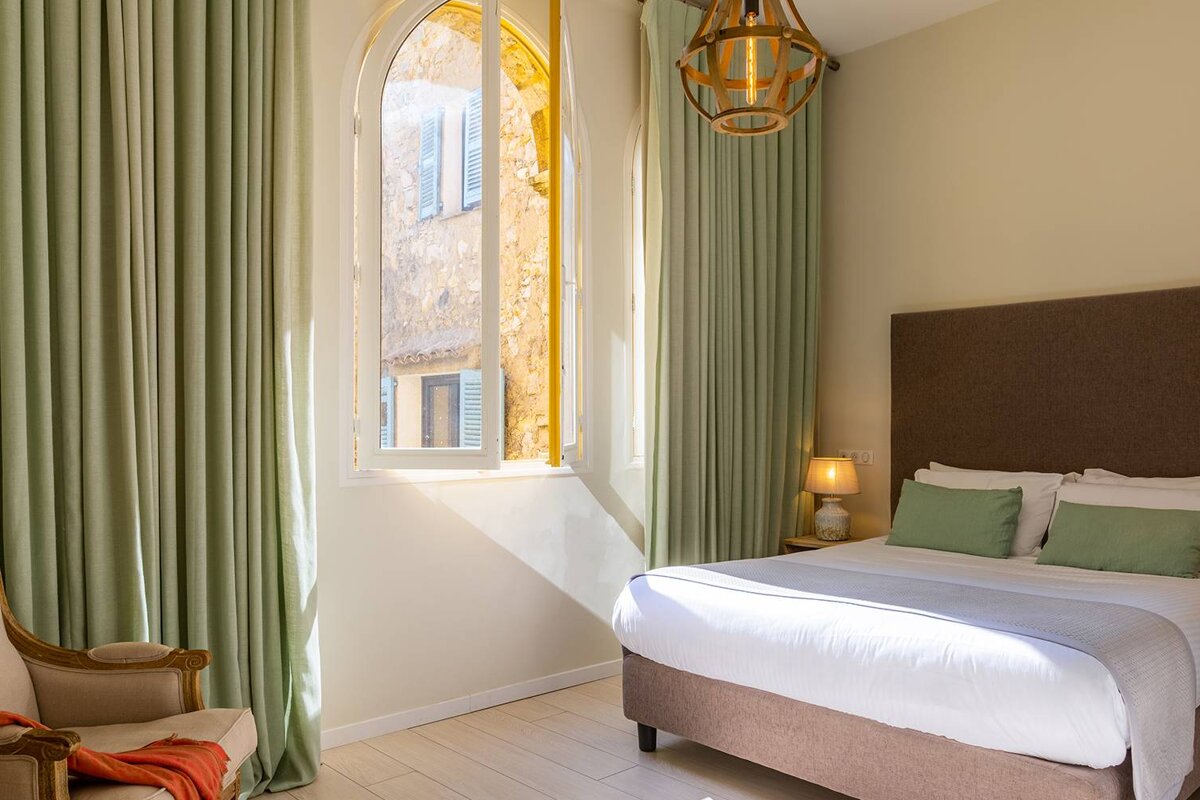 A bedroom with a bed a chair and a window