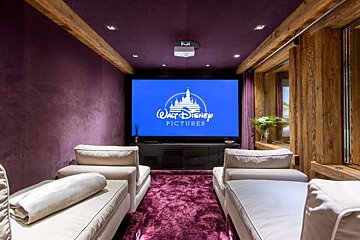A movie theater with a screen that says walt disney pictures
