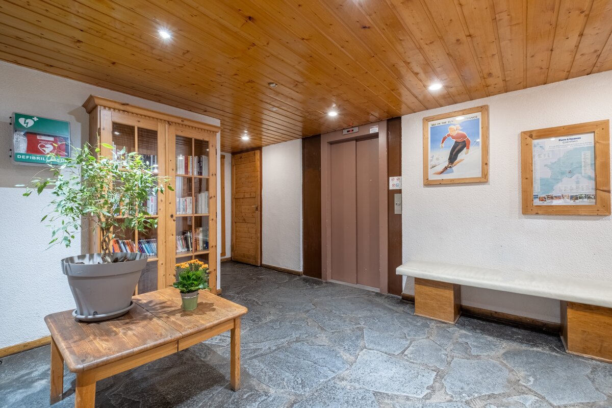 A picture of a man skiing is on a wall next to an elevator