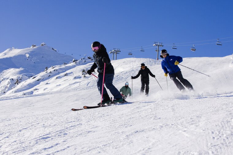 A group of people skiing down a snow covered slope