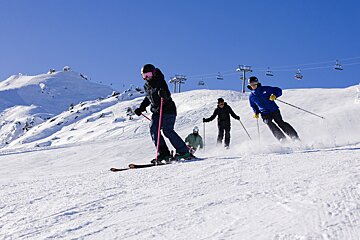 A group of people skiing down a snow covered slope