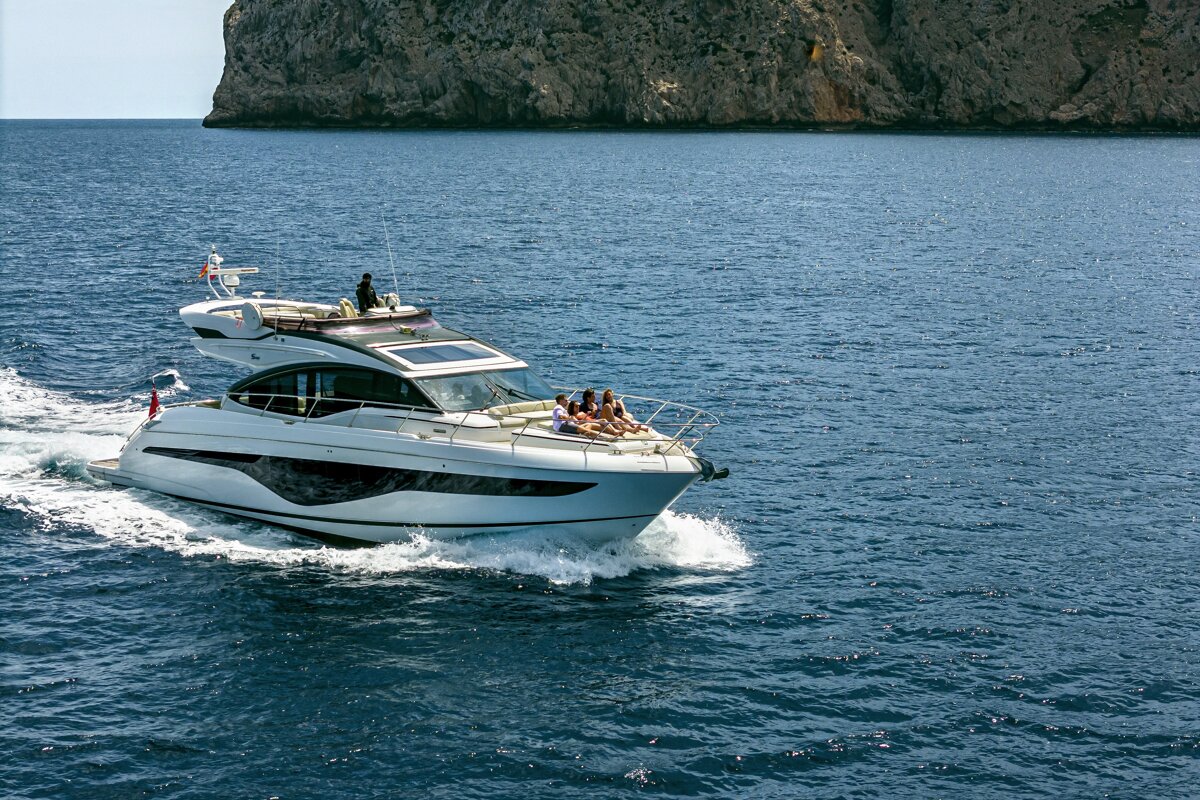 A group of people are sitting on a yacht in the ocean