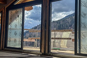 A sliding glass door with a mountain in the background