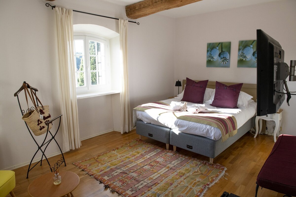 A bedroom with a purple pillow on the bed