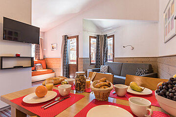 A living room with a couch and a table set for breakfast
