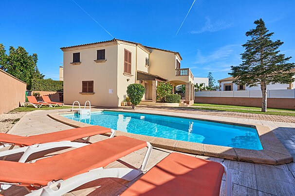 A large house with a swimming pool in front of it