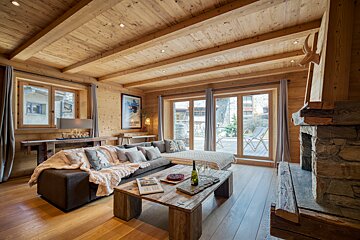 A living room with a couch and a table with a bottle of wine on it