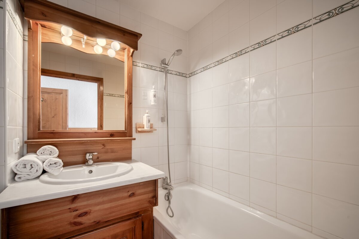 A bathroom with a sink a mirror and a bathtub