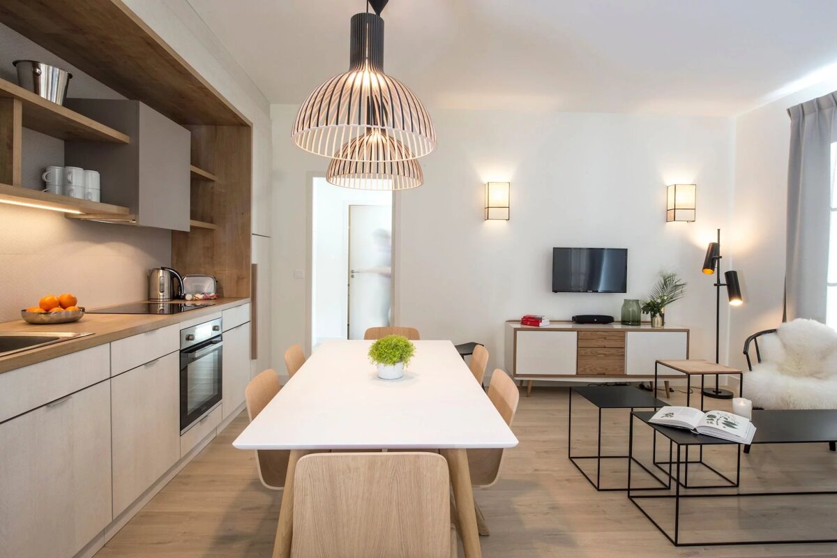 A kitchen with a table and chairs and a tv
