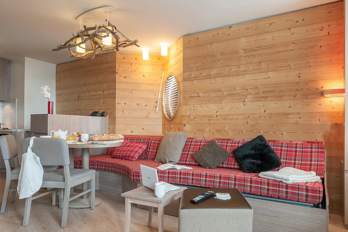 A living room with a red plaid couch and a table