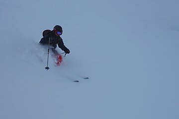 A person is skiing down a snow covered slope