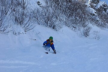 A person is skiing down a snow covered slope