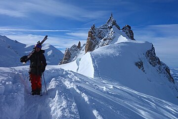 A person standing on top of a snow covered mountain