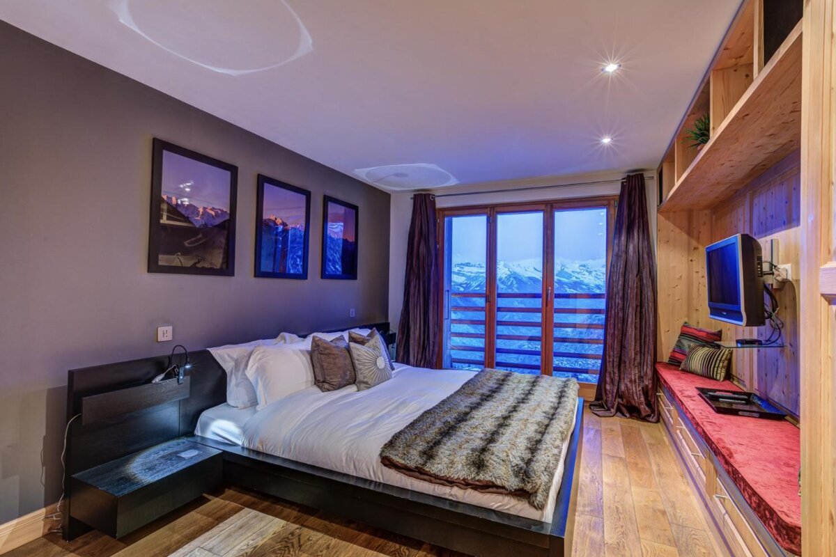 A bedroom with a large bed and a television