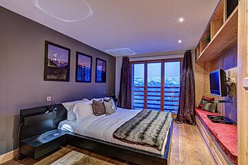 A bedroom with a large bed and a television