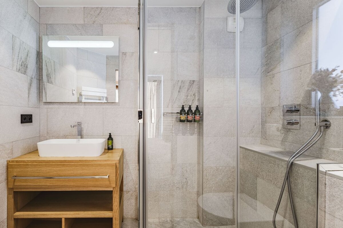 A bathroom with a sink and a walk in shower