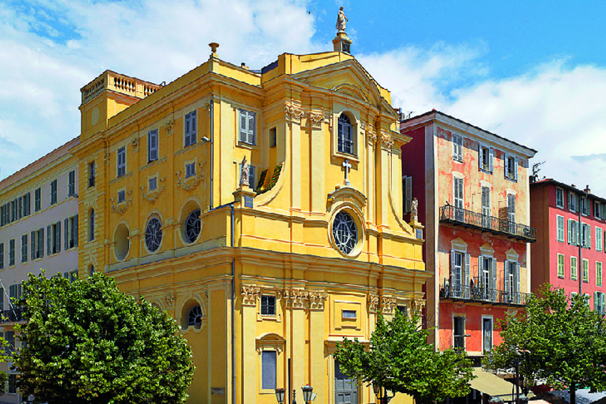 A yellow building with a statue on top of it