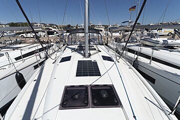 A white service van is parked next to a sailboat