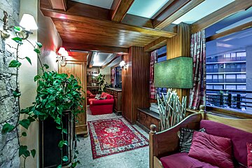 A living room with a red couch and a green lamp