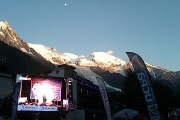 A large screen with a mountain in the background and a sign that says nasa