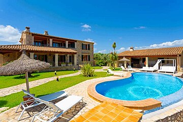 A large house with a large swimming pool in front of it