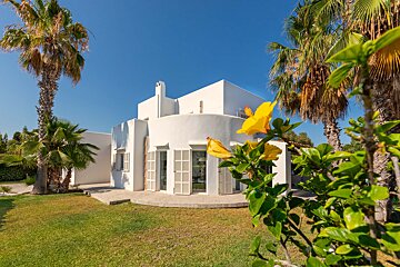 A white house with a yellow flower in front of it