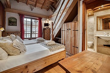 A bedroom with two beds and a bathroom with a sink