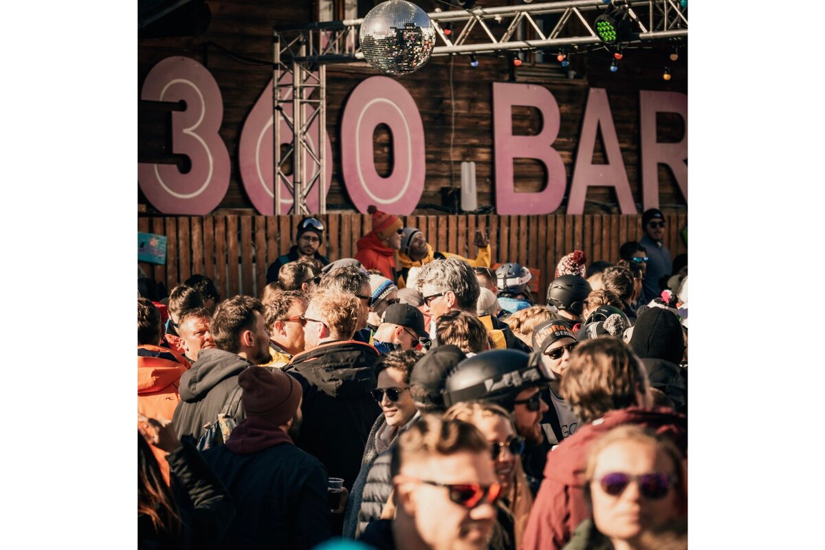 A crowd of people are gathered under a sign that says 300 bar