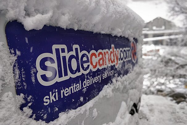 A slidecandy.com sign is covered in snow