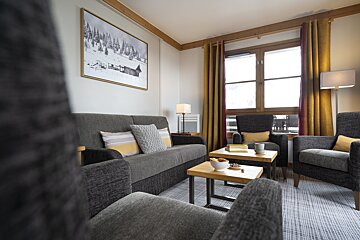 A living room with a couch and two chairs