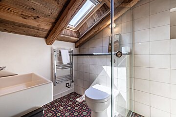 A bathroom with a skylight above the toilet