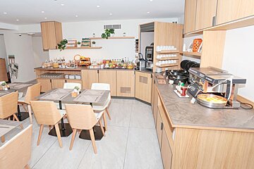 A buffet area with tables and chairs and a machine that says ' coca cola ' on it