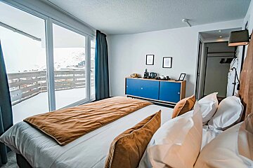 A hotel room with a large bed and a blue cabinet