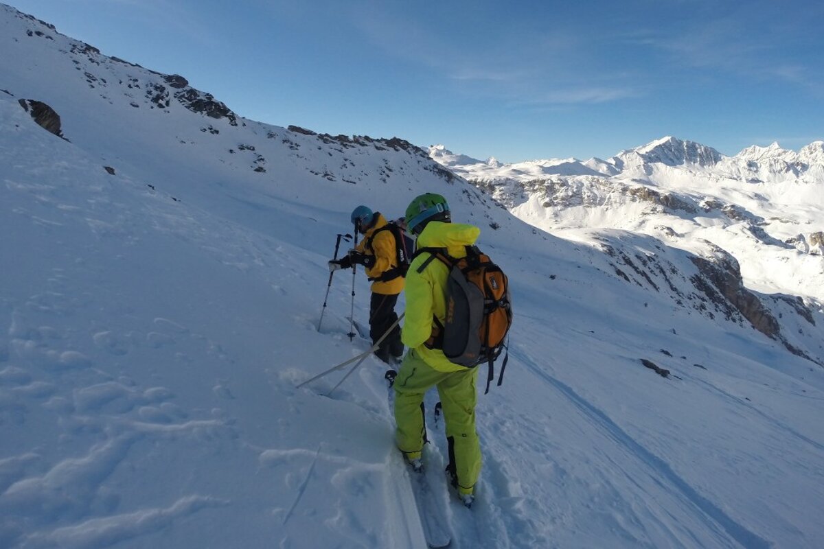 Two people skiing down a snow covered mountain