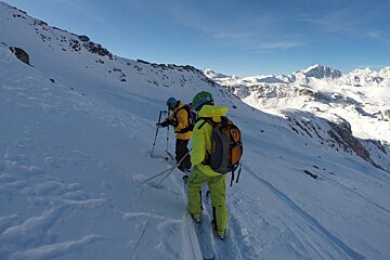 Two people skiing down a snow covered mountain