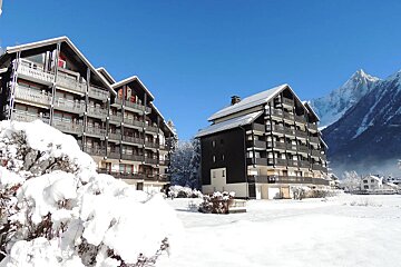Snow covered buildings with a mountain in the background