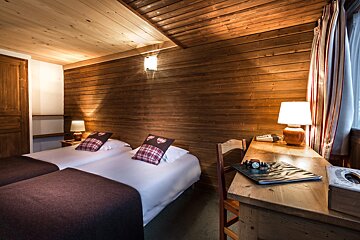 A hotel room with two beds and a desk