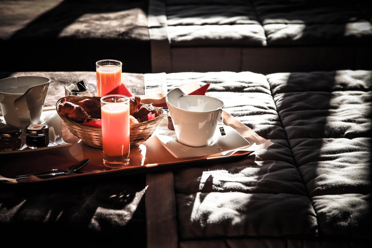 A tray with a cup of coffee and a basket of bread