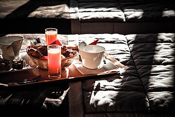 A tray with a cup of coffee and a basket of bread