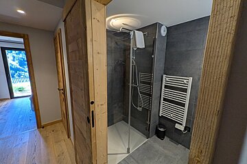 A bathroom with a walk in shower and a towel rack