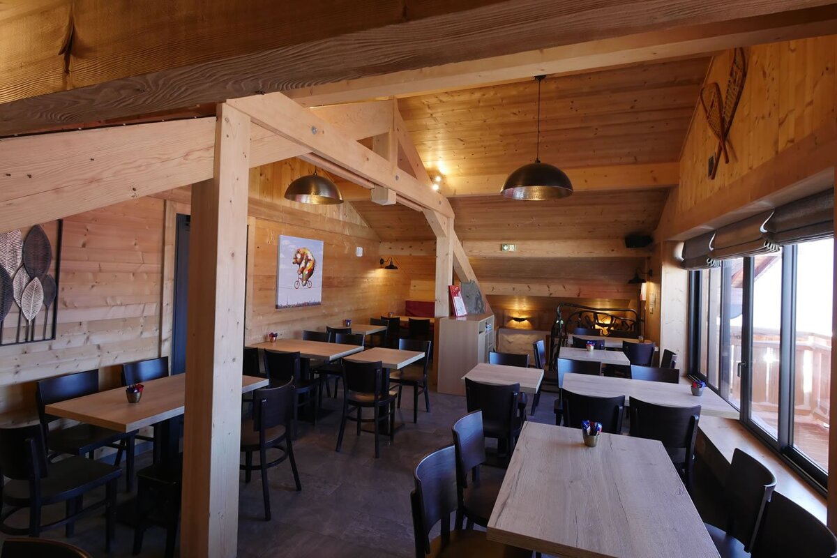 A restaurant with tables and chairs and a painting on the wall