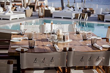 A table with glasses and plates and chairs that say aaa