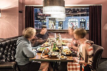 A group of people sitting at a table with plates of food