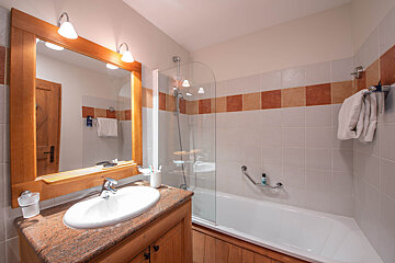 A bathroom with a sink a mirror and a bathtub