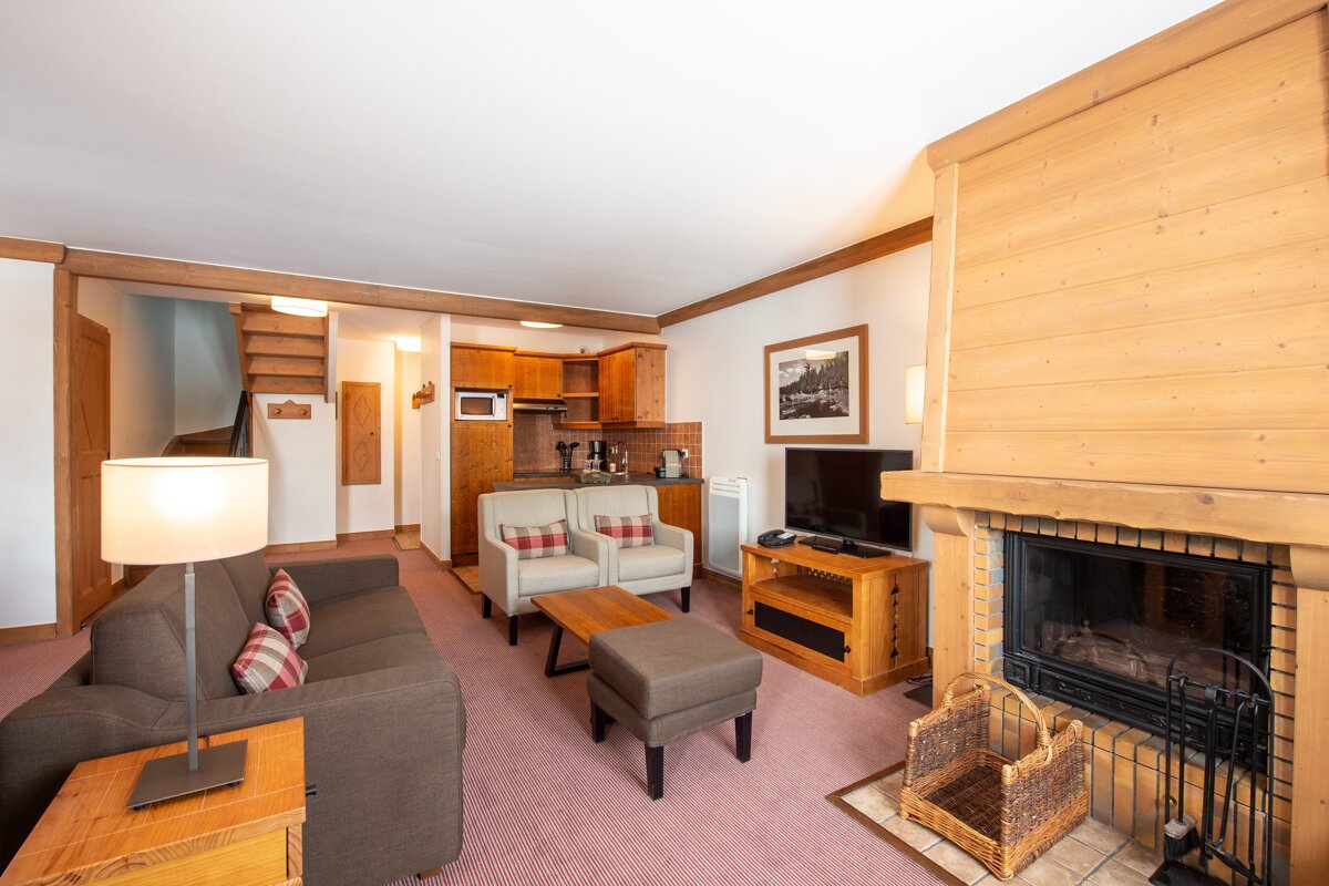 A living room with a couch and chairs and a fireplace