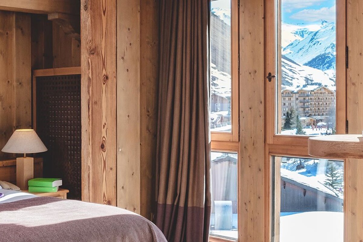 A bedroom with a view of a snowy mountain